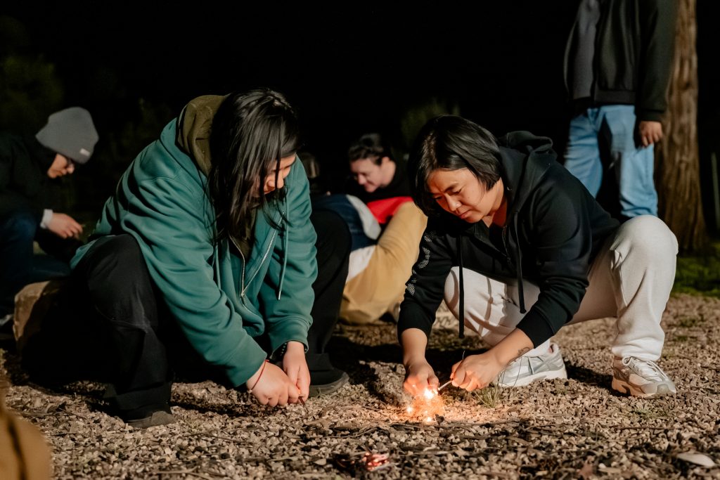 Nepali scholars Rubina Bishunke (left) and Rita Baramu (right) try their hand at making fire.
